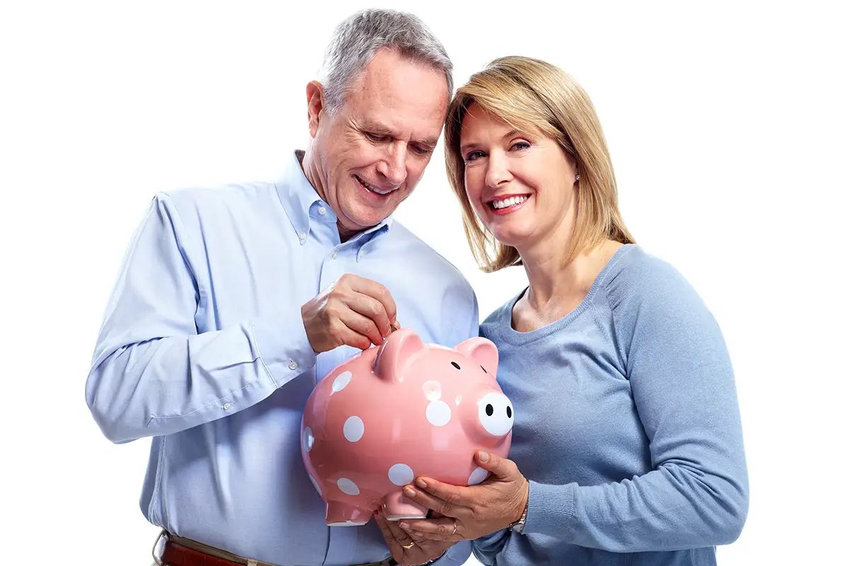 Older couple putting money away in their pigy-bank